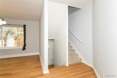 Staircase with hardwood / wood-style floors and baseboards