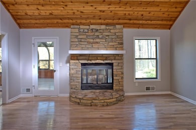 Unfurnished living room with visible vents, wood c