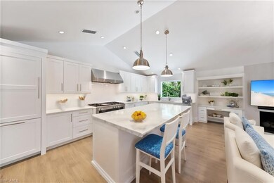 Kitchen with range, white cabinetry, light hardwoo