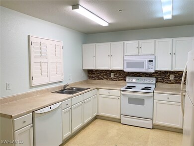 Kitchen with white appliances, backsplash, white c