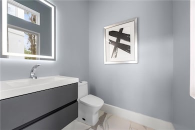 Bathroom featuring vanity and light marble finish flooring