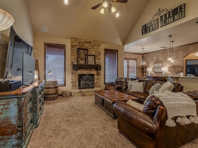 Living room with a stone fireplace, ceiling fan, c