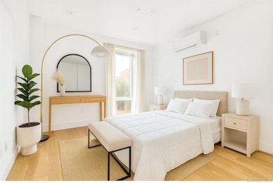 Bedroom featuring light wood finished floors and an AC wall unit