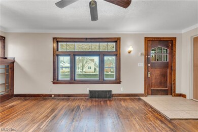 Foyer featuring light tile flooring, ceiling fan, and crown molding
