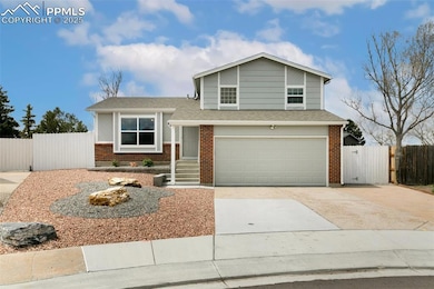 Tri-level home with brick siding, a garage, and fe