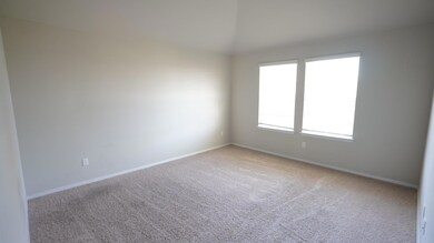 Empty room featuring carpet floors and vaulted ceiling