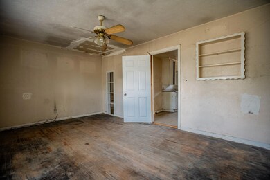 Spare room with hardwood / wood-style flooring, a textured ceiling, built in features, and ceiling fan