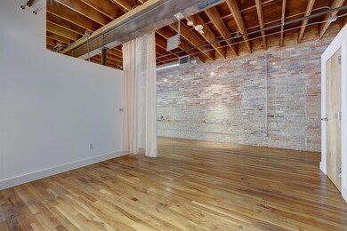 Basement with brick wall and wood finished floors