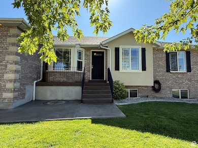 View of front facade featuring a front yard, brick siding, and stucco siding
