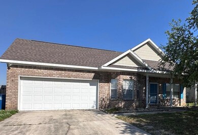 View of front facade with concrete driveway, brick siding, roof with shingles, and an attached garage