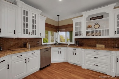 Kitchen featuring dishwasher, white cabinetry, a s
