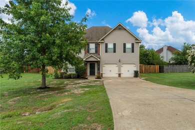 View of front of property featuring a garage, driveway, brick siding, and roof with shingles