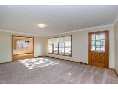 Large living room with hardwood under carpet.