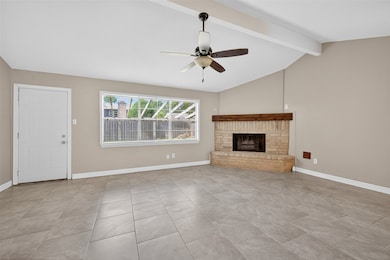 Enjoy the spacious living room with a
vaulted ceiling, elegant tile flooring, and
a cozy brick fireplace. Abundant natural
light flows through a large window,
complemented by a ceiling fan for
added comfort.