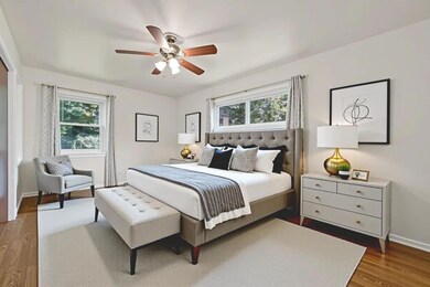 Bedroom with multiple windows, dark wood finished floors, and ceiling fan