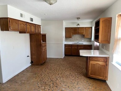 Kitchen featuring sink, backsplash, and a textured