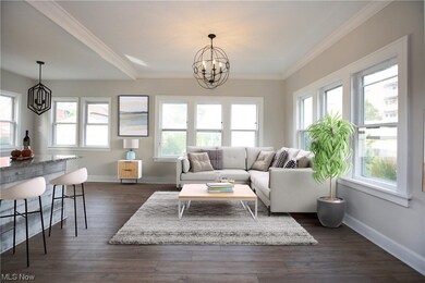 Living room with a chandelier, dark wood-type flooring, and ornamental molding