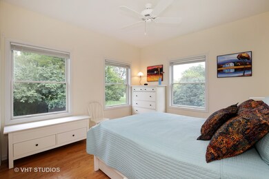 2nd bedroom with ceiling fan and hardwood floors.