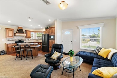 Living area with crown molding, recessed lighting, and light wood-style floors