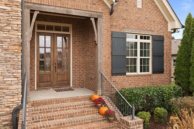 Immaculate entryway surrounded by meticulous landscaping