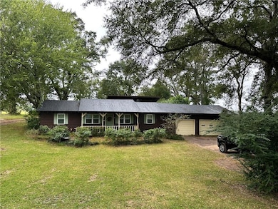 Ranch-style house featuring a front yard and a gar