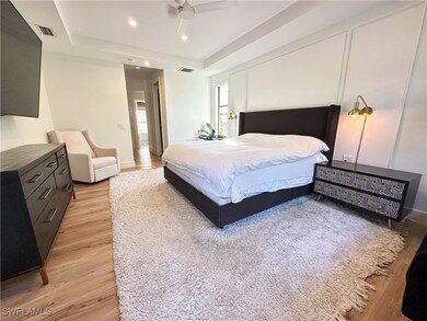 Bedroom featuring a raised ceiling and light hardw