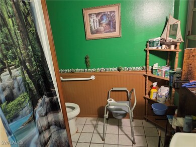 Bathroom with wainscoting and tile patterned floor