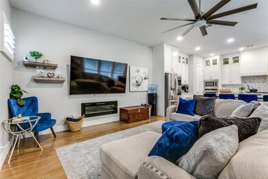 Living room with ceiling fan and light hardwood / 