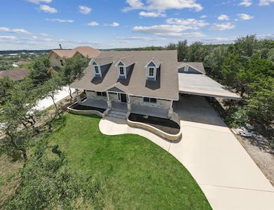 New england style home with a front yard, drivewa