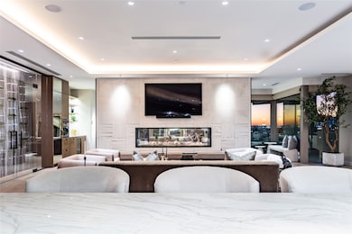 Artfully designed Limestone see-through fireplace wall with floating wood hearth.