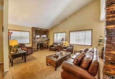 Sunken living room is graced with stacked stone fi