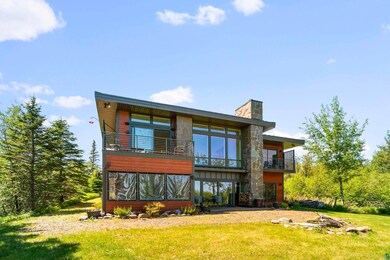 Rear view of house with a balcony and a yard