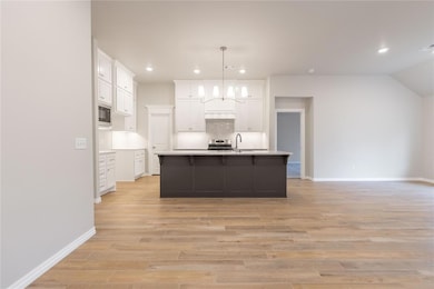 Kitchen with white cabinetry, a kitchen island wit