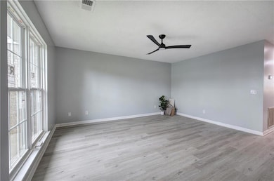Great room with plenty of natural light, new light LVP flooring and new ceiling fan.