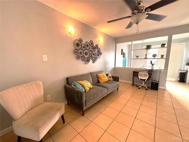 Living room featuring light tile patterned floors, baseboards, and a ceiling fan