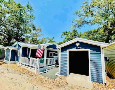 View of front of home with a storage shed and a porch