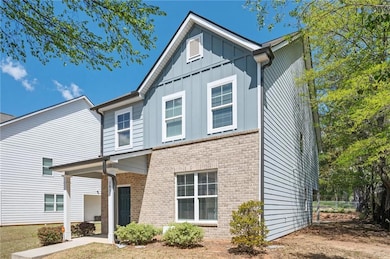 View of front of house featuring board and batten siding and brick siding
