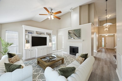 *This photo is virtually staged* The family room is at the rear of the home and has a vaulted ceiling, built-in entertainment center and fireplace.