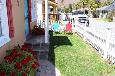 White picket fenced front yard with slate entry.