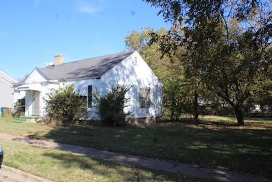 View of side of home with a lawn and a chimney