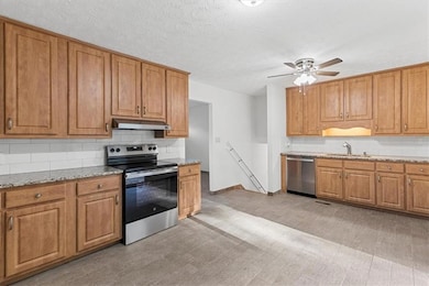 Kitchen featuring light stone countertops, applian