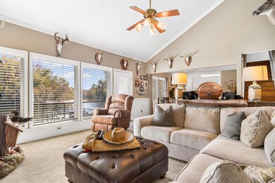 Living room featuring ceiling fan, high vaulted ce