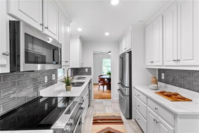 Kitchen with stainless steel appliances, white cabinetry, recessed lighting, and tasteful backsplash
