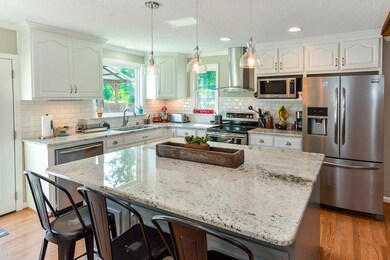 THIS KITCHEN!!  Beautiful windows, oversized island,  granite countertops, updated cabinetry, stainless steel appliances to remain, & a picture window looking out into the back yard.