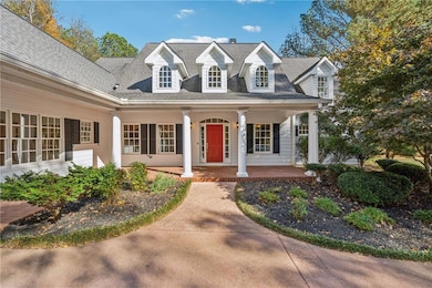Cape cod house featuring covered porch