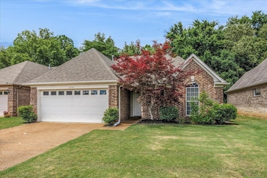 View of front of property with a garage, brick siding, driveway, roof with shingles, and a front lawn