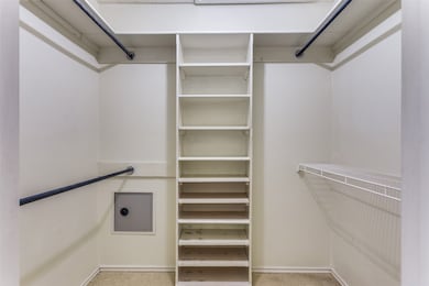 Walk in closet in primary bathroom featuring built in shelves