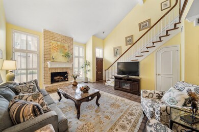 The foyer of the home with recessed lighting and a wood-stained front door with beveled glass transom above opens to the living & dining rooms.