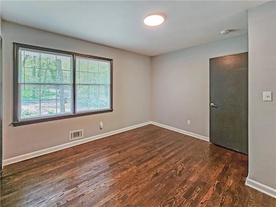 Spare room featuring wood finished floors and baseboards