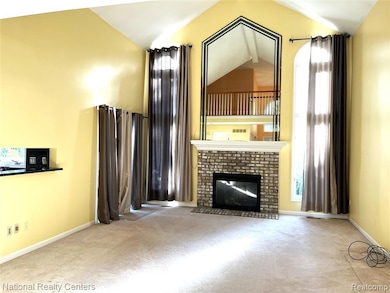 Unfurnished living room with high vaulted ceiling, carpet, and a fireplace